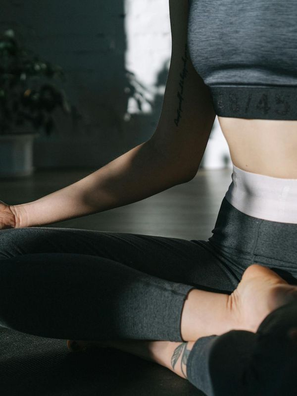 Woman in a calm yoga pose in a bright, minimalist room.